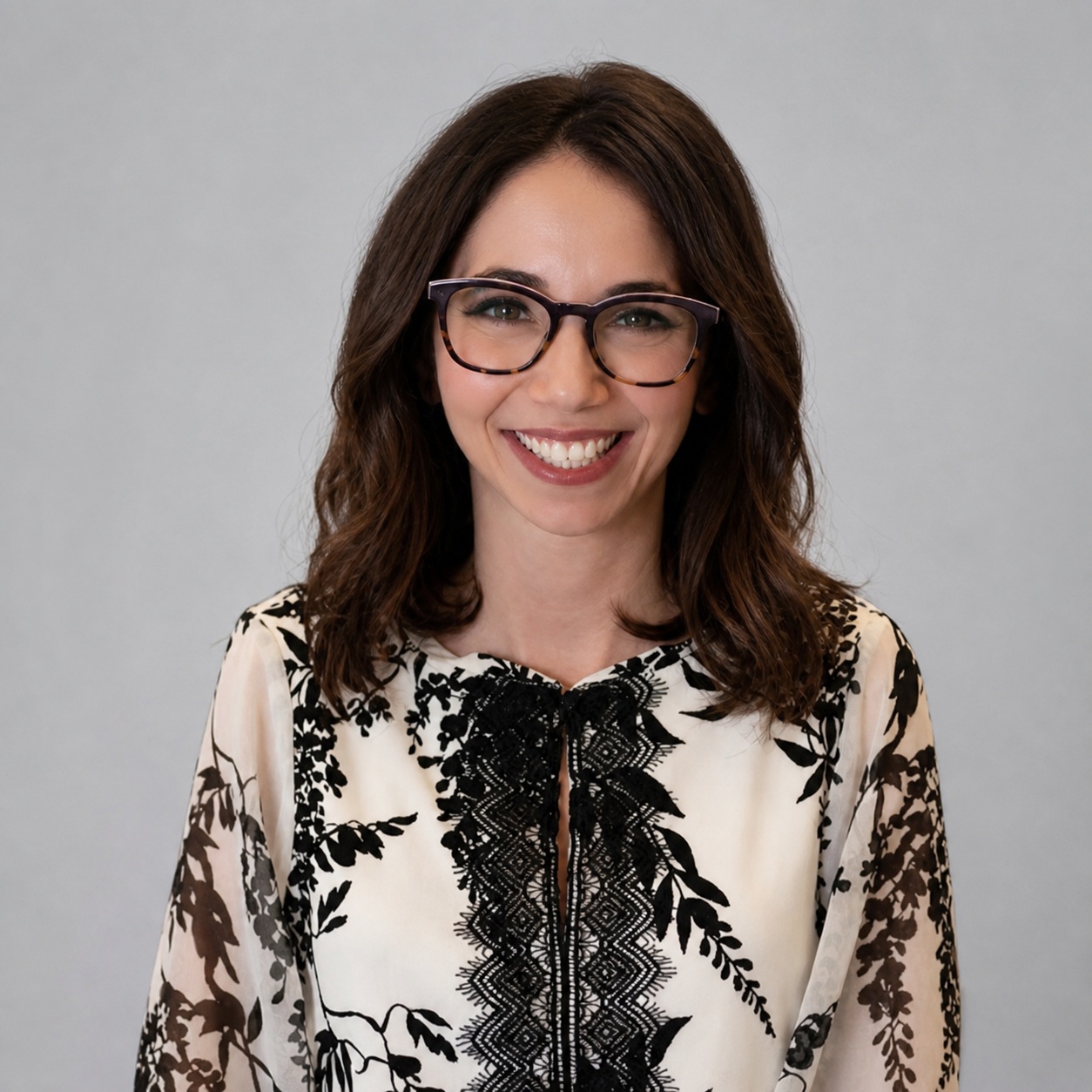 Ellen Koch, Fractional CMO, smiling with glasses in a floral blouse